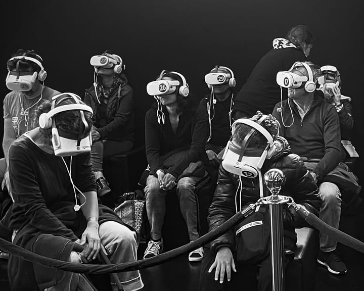 Derrière un cordon, un groupe de gens est plongé dans une expérience de réalité virtuelle.